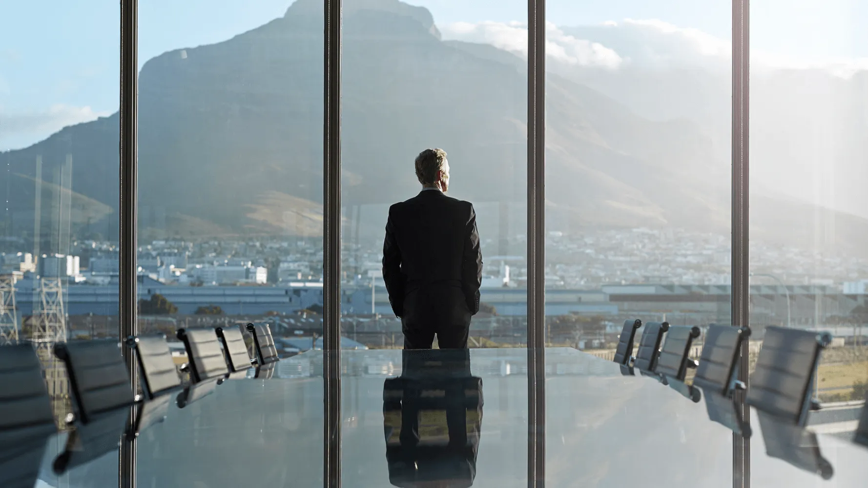 Man looks out at a beautiful view from a conference room