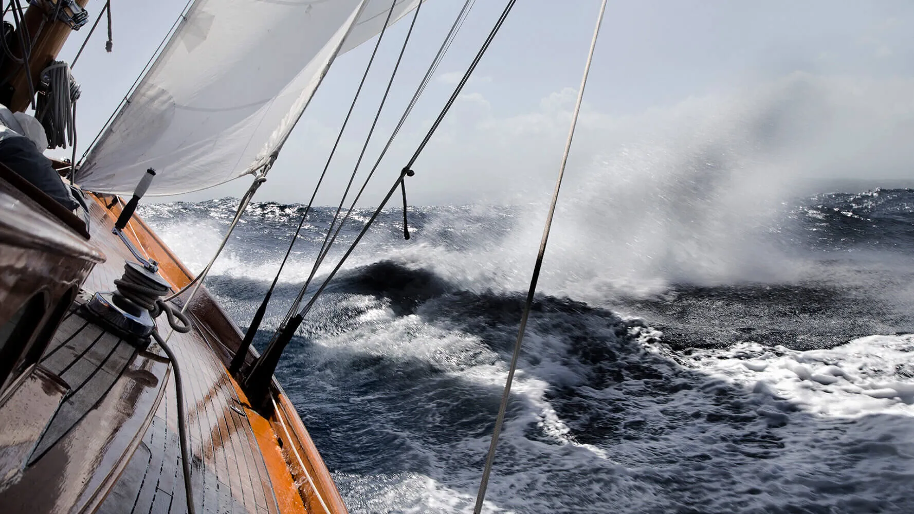Yacht leaning in rough sea.